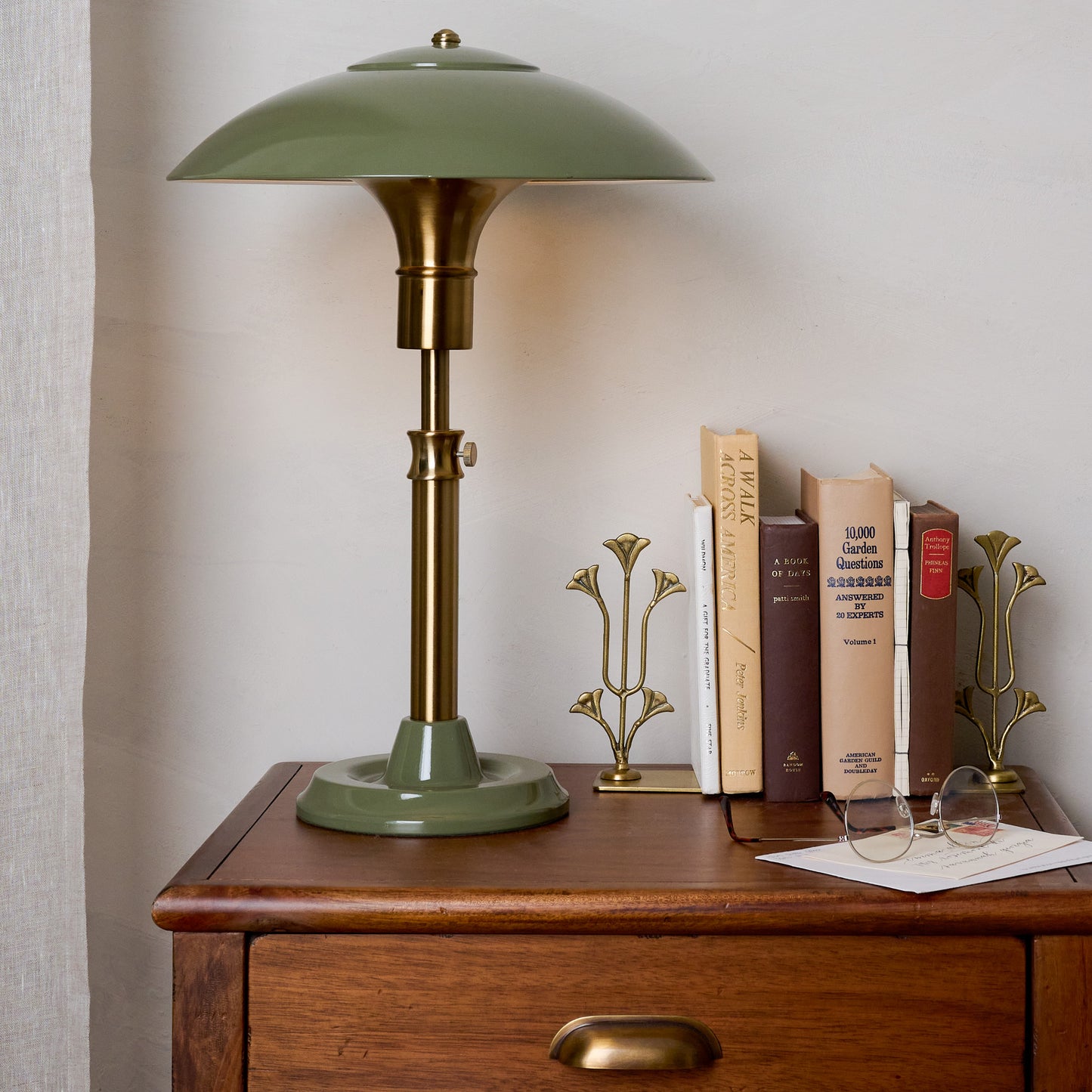 Antique Brass Tulip Bookends shown holding books on table