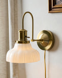 Polly Milk Glass Plug-in Sconce shown on wall