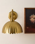 Callan Fluted Brass Wired Sconce next to wall art