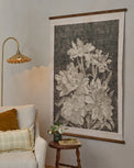 Vintage Bloom Sketch Tapestry in a room next to accent chair and brass pleated floor lamp