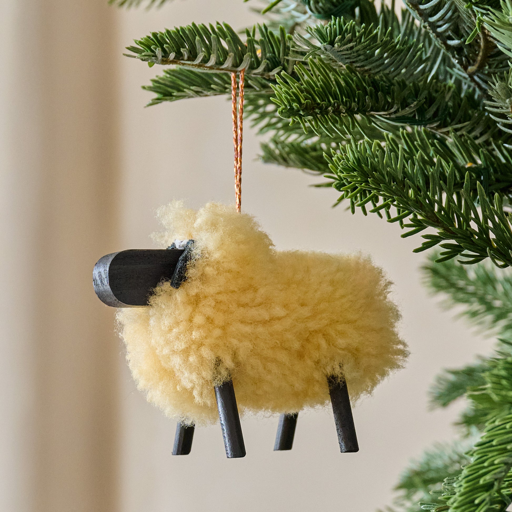 Cream Handcrafted Shearling Sheep Ornament shown hung from tree