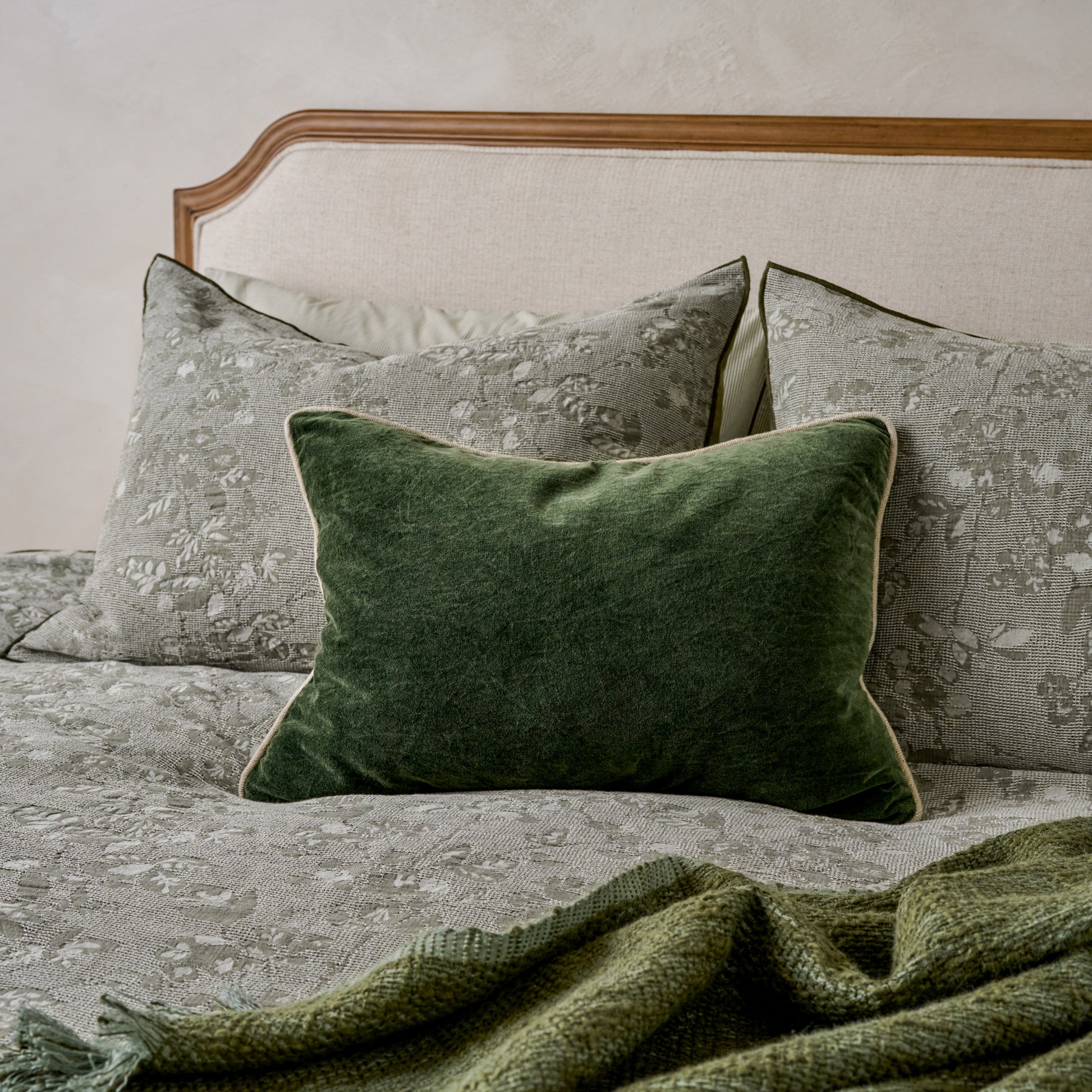 Heirloom Velvet Lumbar Pillow - Forest Green shown on bed