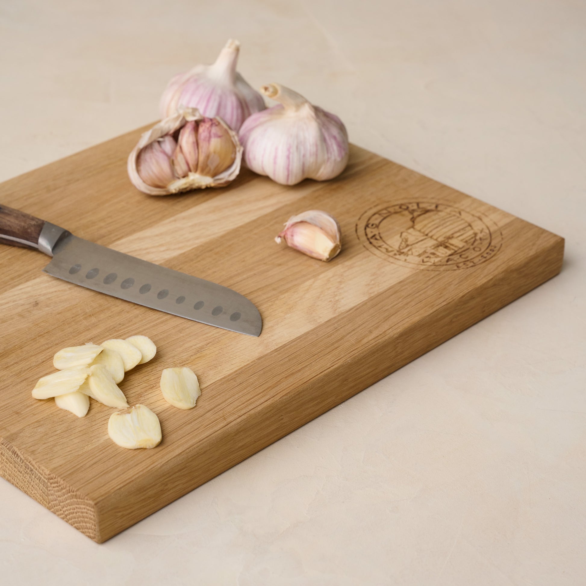 Magnolia Seal Cutting Board with chopped garlic on top