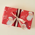 Red Santa Three Sheet Wrapping Roll shown on gift