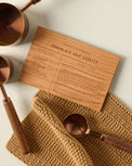 Wooden Recipe Card (Chocolate Chip Cookies) with measuring cups and towel