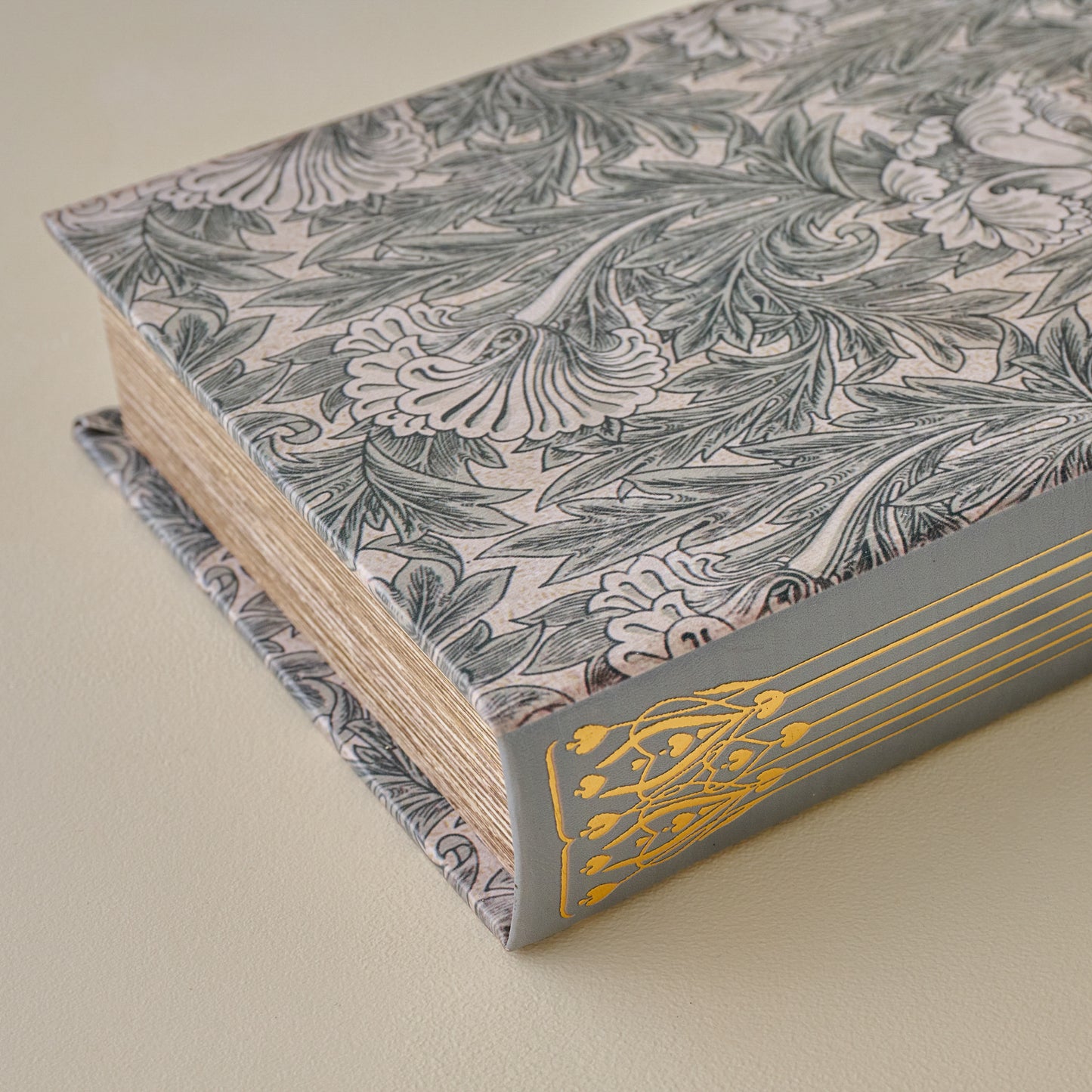 Floral-patterned Vintage-Inspired Handcrafted Book Box with gold leaf design on a beige background