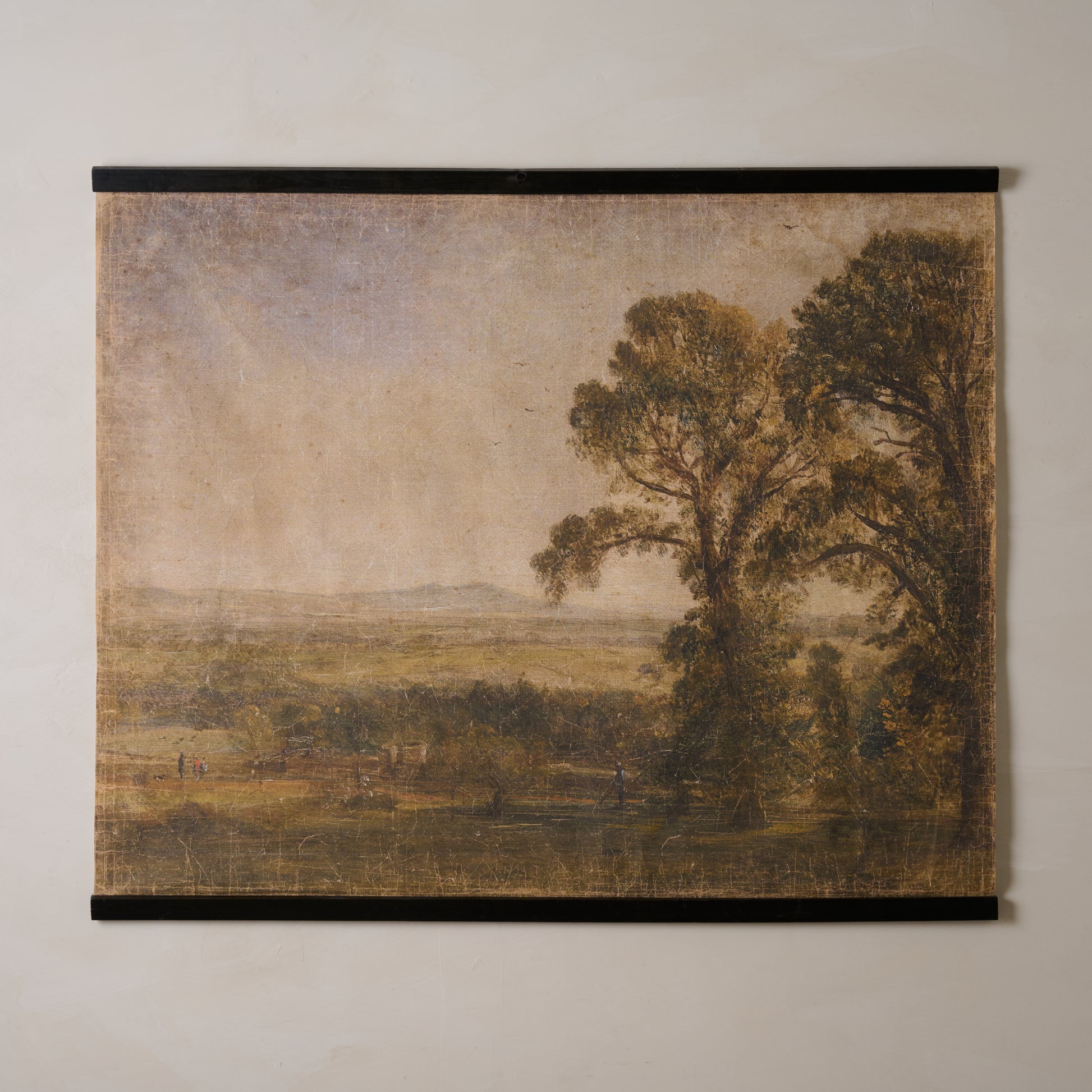 Landscape tapestry with trees and open field on a textured wall.