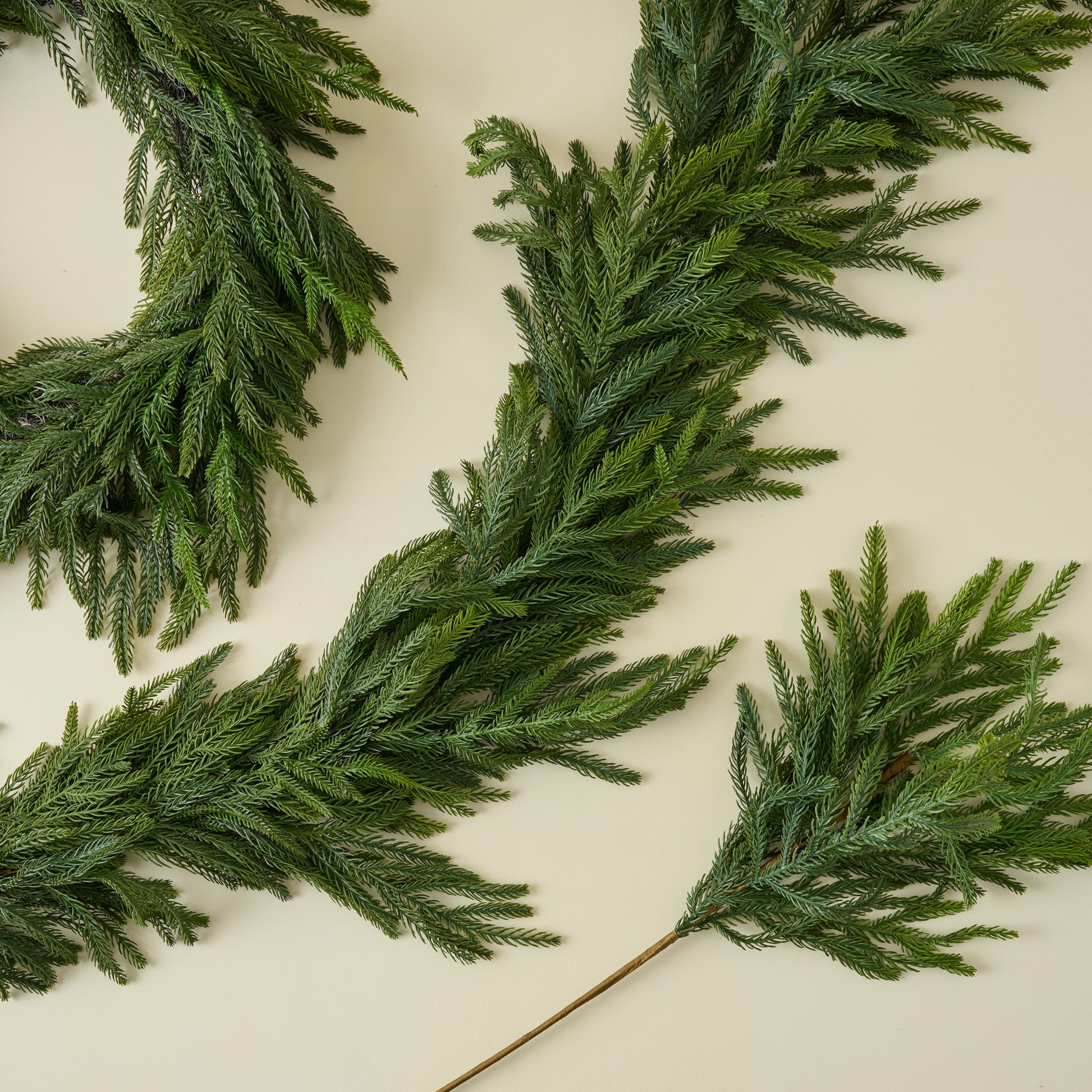 Real Touch Norfolk Pine Wreath shown with coordinating pine stem and garland