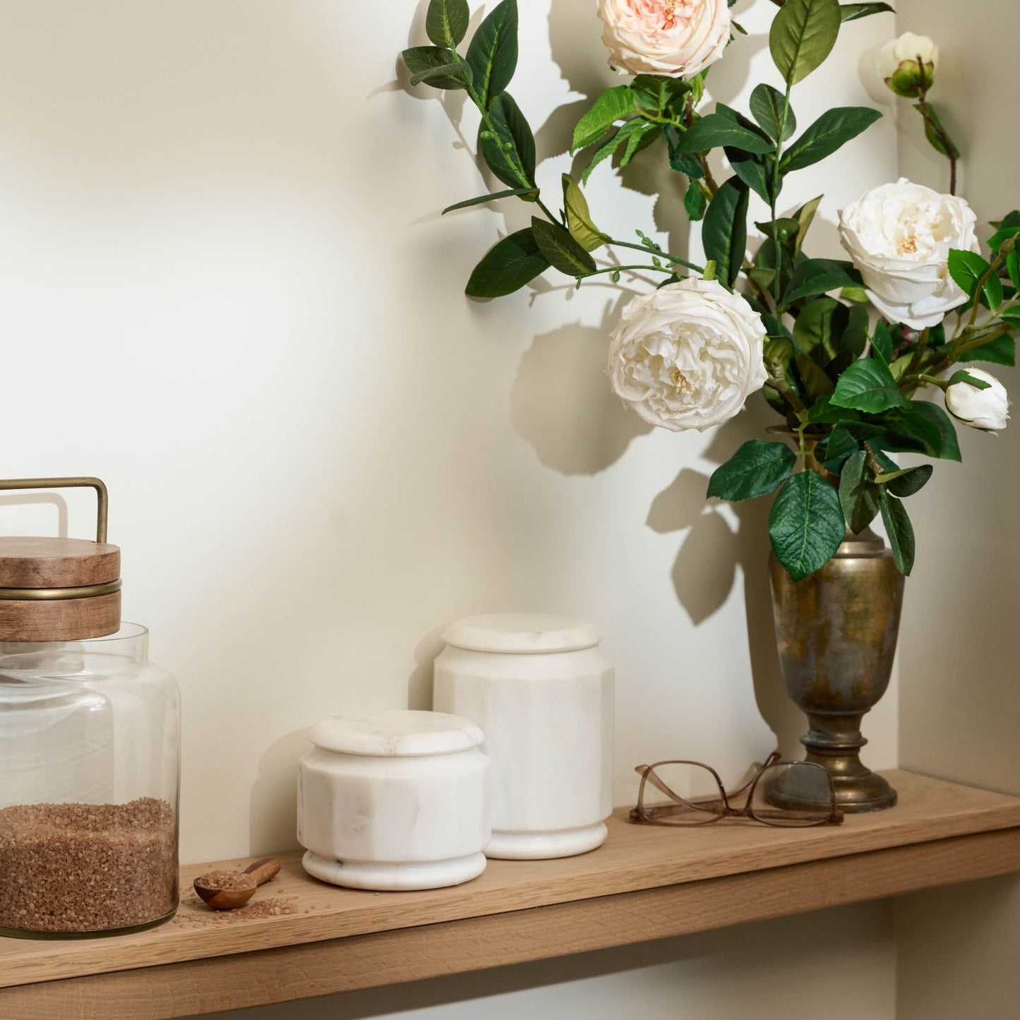 white marble canisters on bathroom shelf
