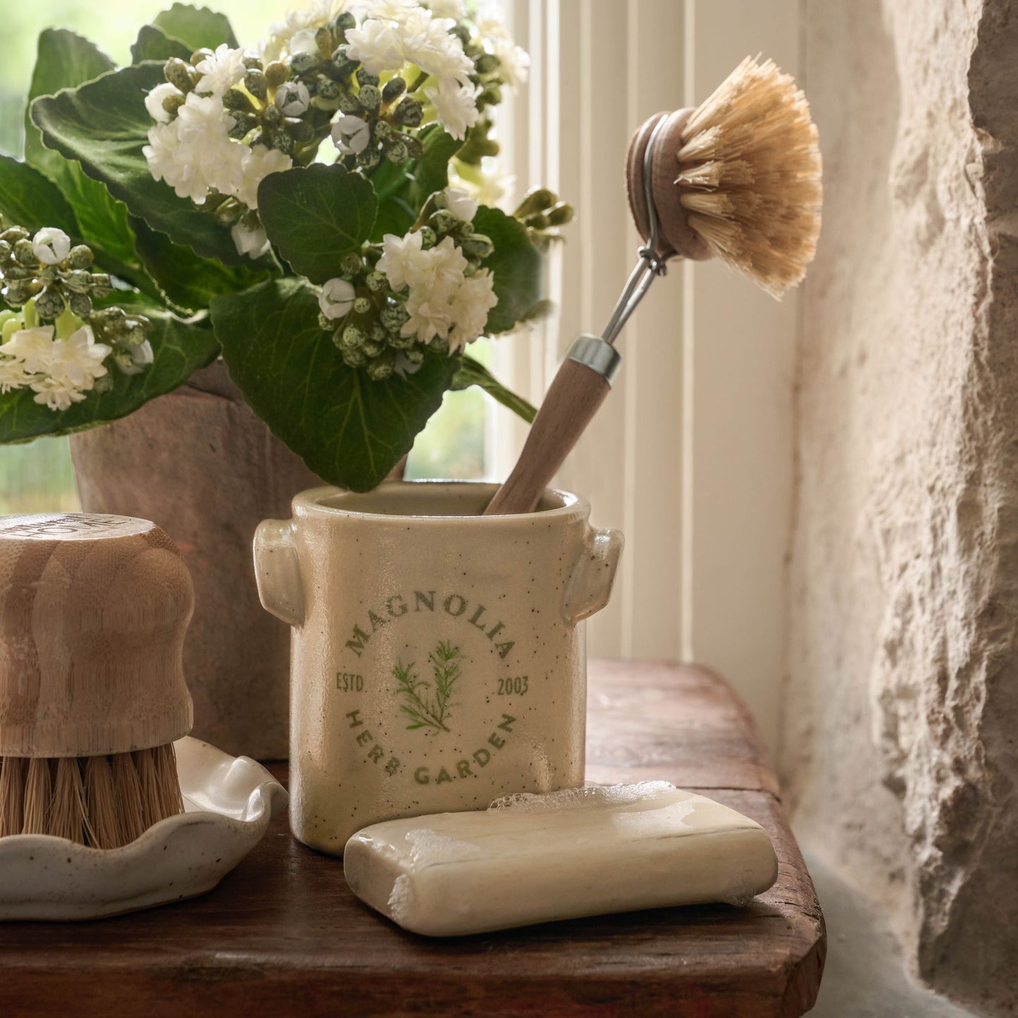 emptied Magnolia Herb Garden Candle with dish brush