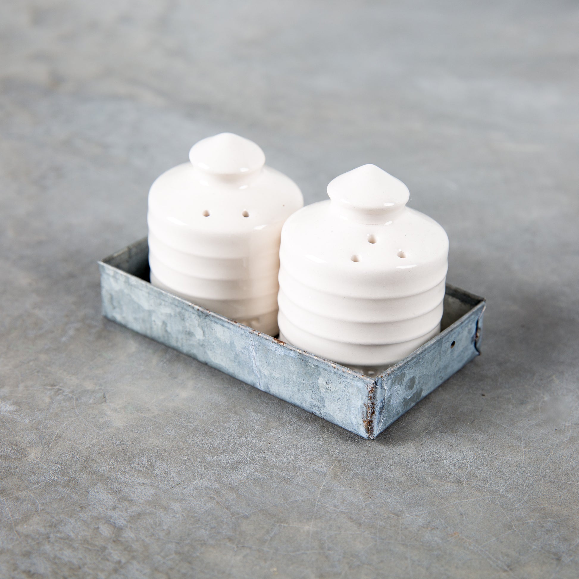 white ceramic salt and pepper shaker set shaped like silos in galvanized tin tray set