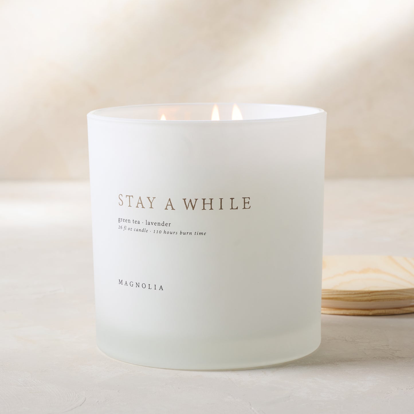 magnolia stay a while candle with wood lid notes scents of green tea and lavender