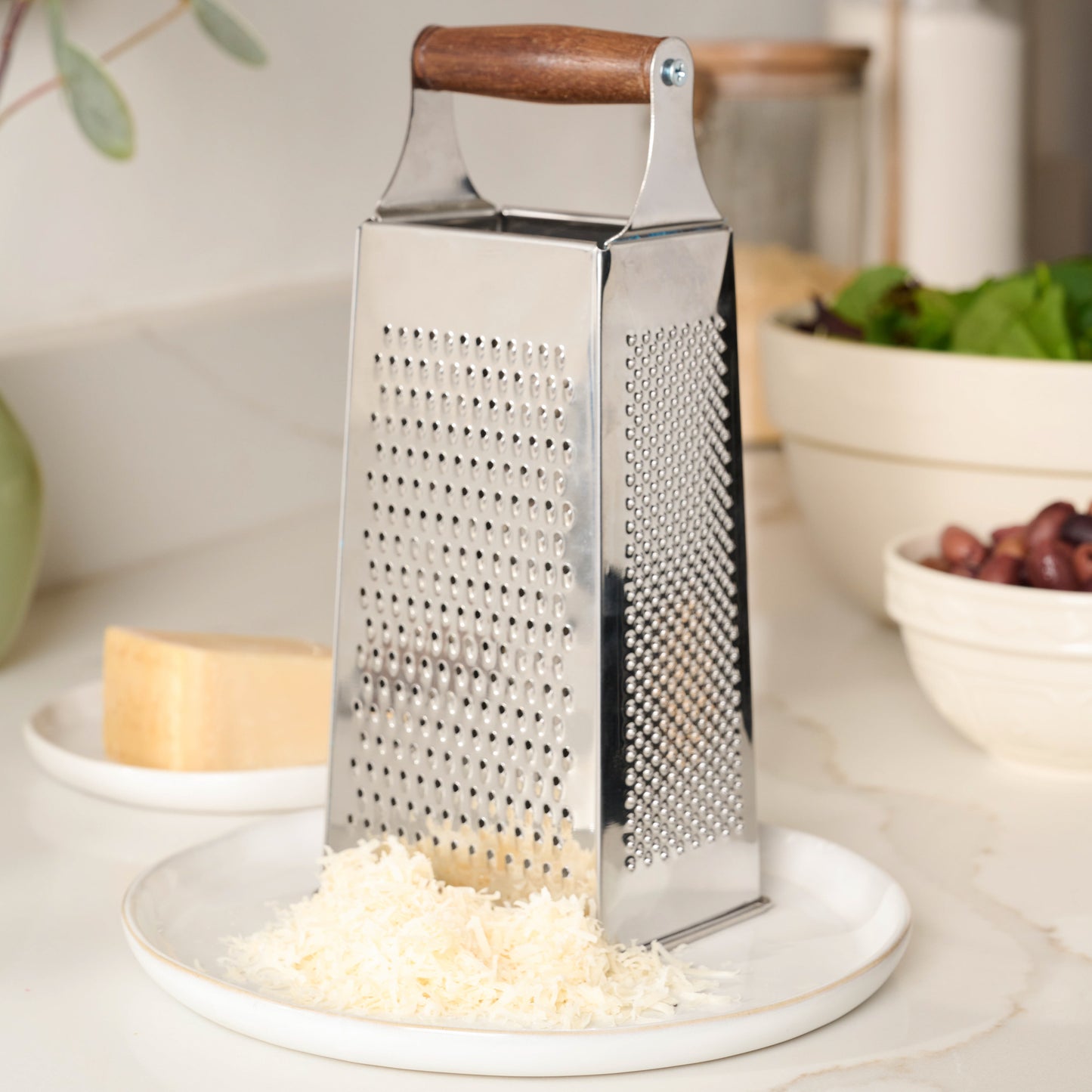Gristmill Collection Walnut Handle Cheese Grater on plate with cheese