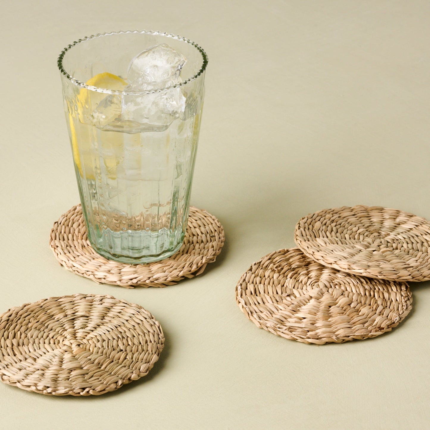 magnolia elizabeth bottle cut glass tumbler in tall size on wicker coaster