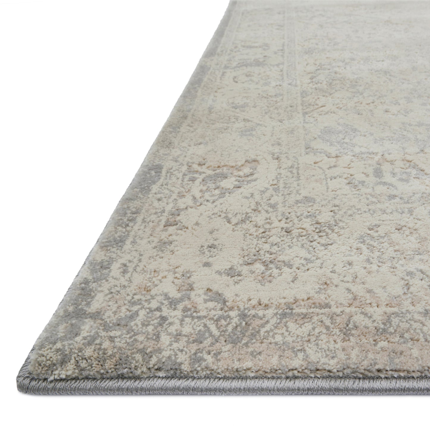 pale cream and grey distressed rug with faint floral detail