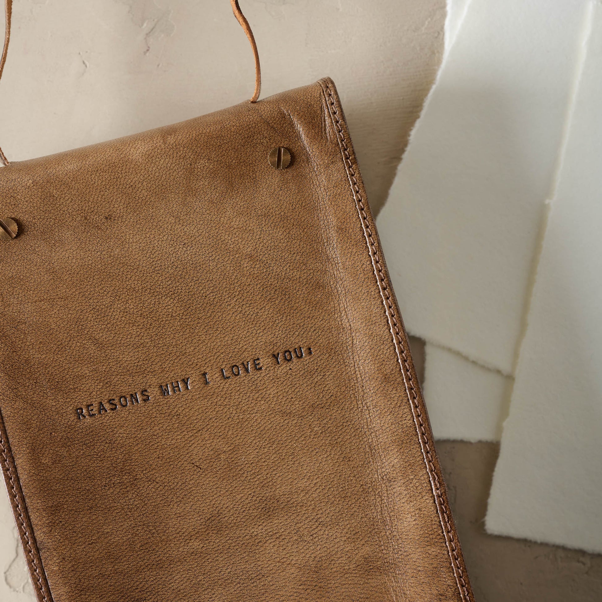 Close up of front cover of notebook that reads in branded text "Reasons why I love you"
