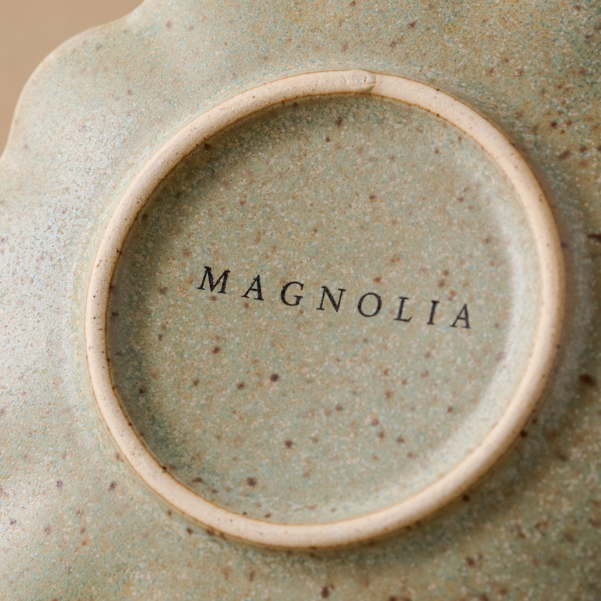 Close up of magnolia logo on bottom of Scalloped Edge Stoneware Coaster
