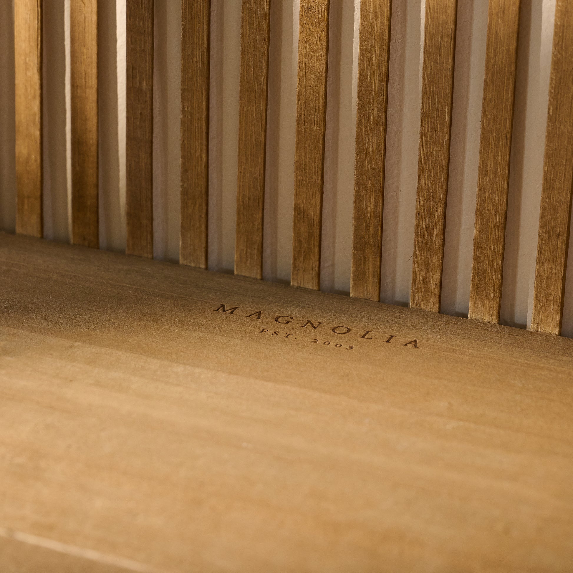Close up of magnolia logo embossed on shelf of Preston Reeded Wall Shelf