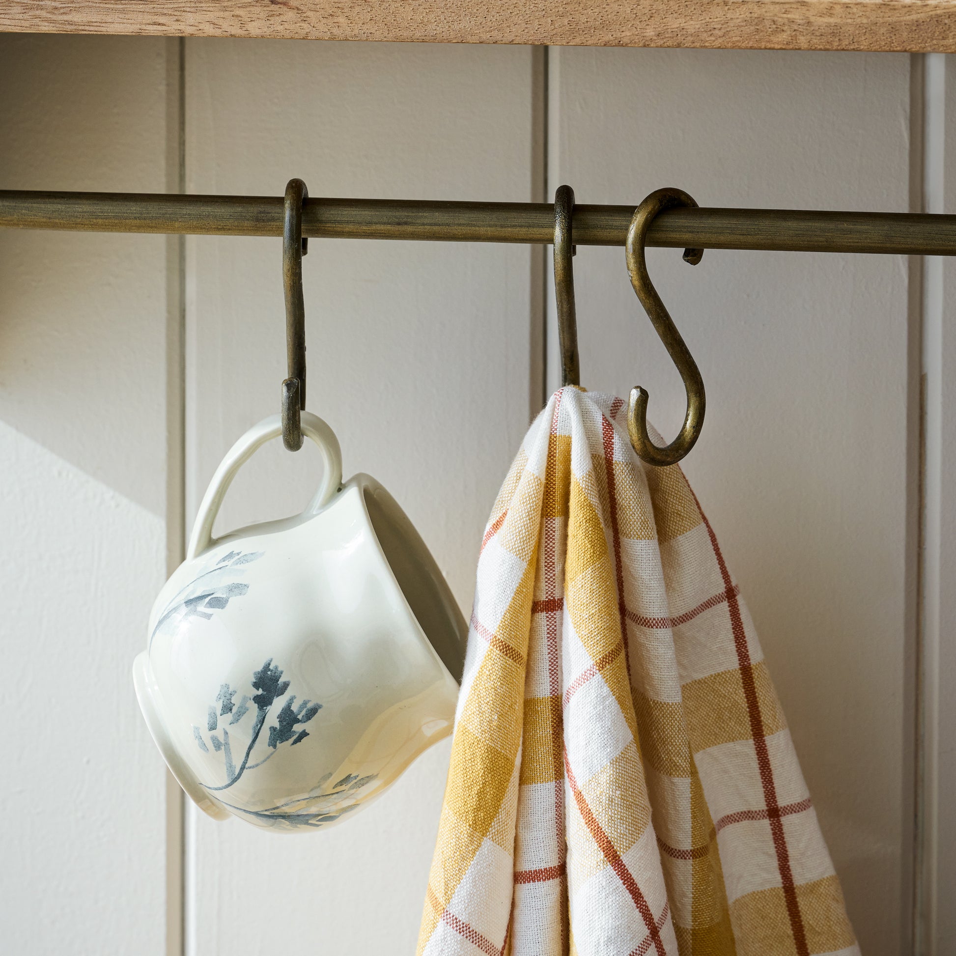 Hannon Wood and Brass Display Shelf hooks holding mug and a napkin
