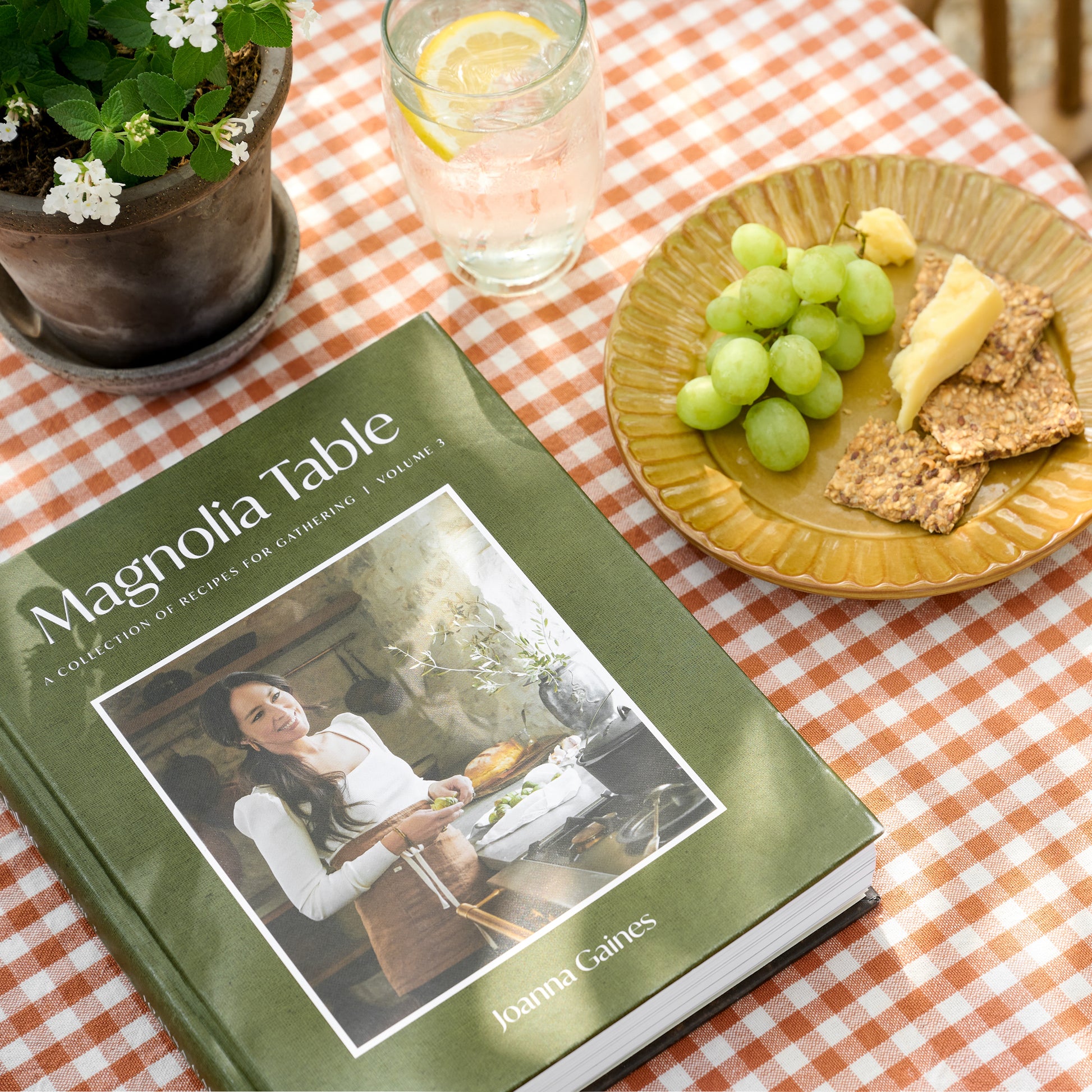 Magnolia Table Cookbook Volume 3 on a picnic table
