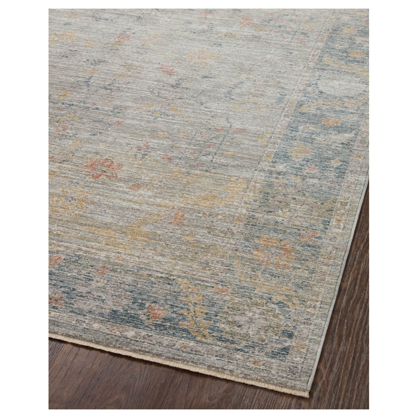 Millie Slate Multi Rug corner of wood floor