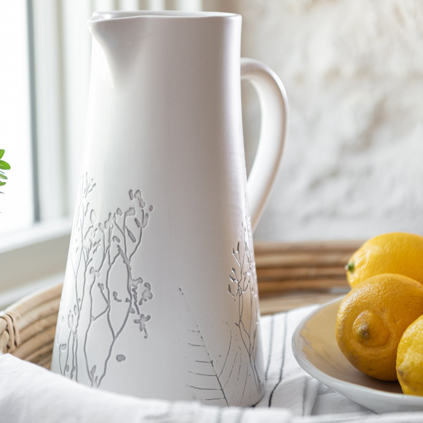tapered white ceramic pitcher with embossed pressed floral print detail