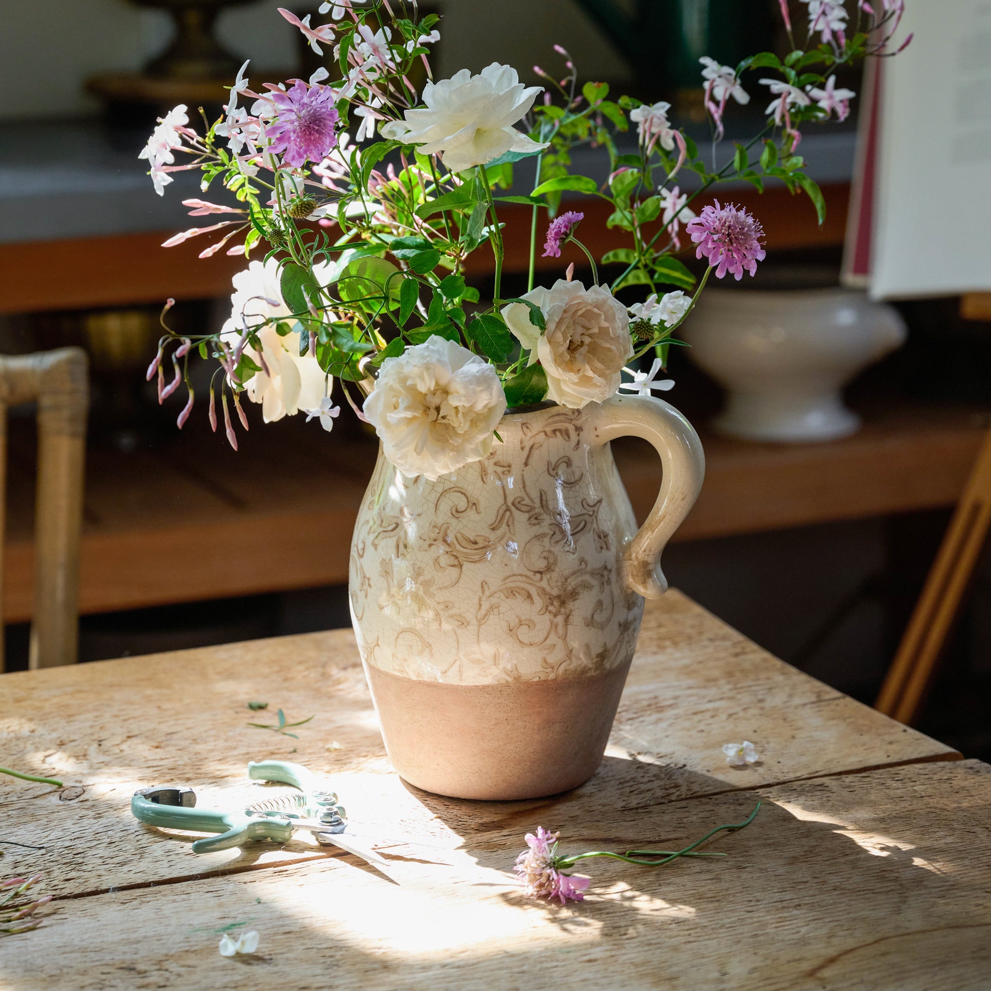Pale Mint Pruning Shears next to a vase with florals