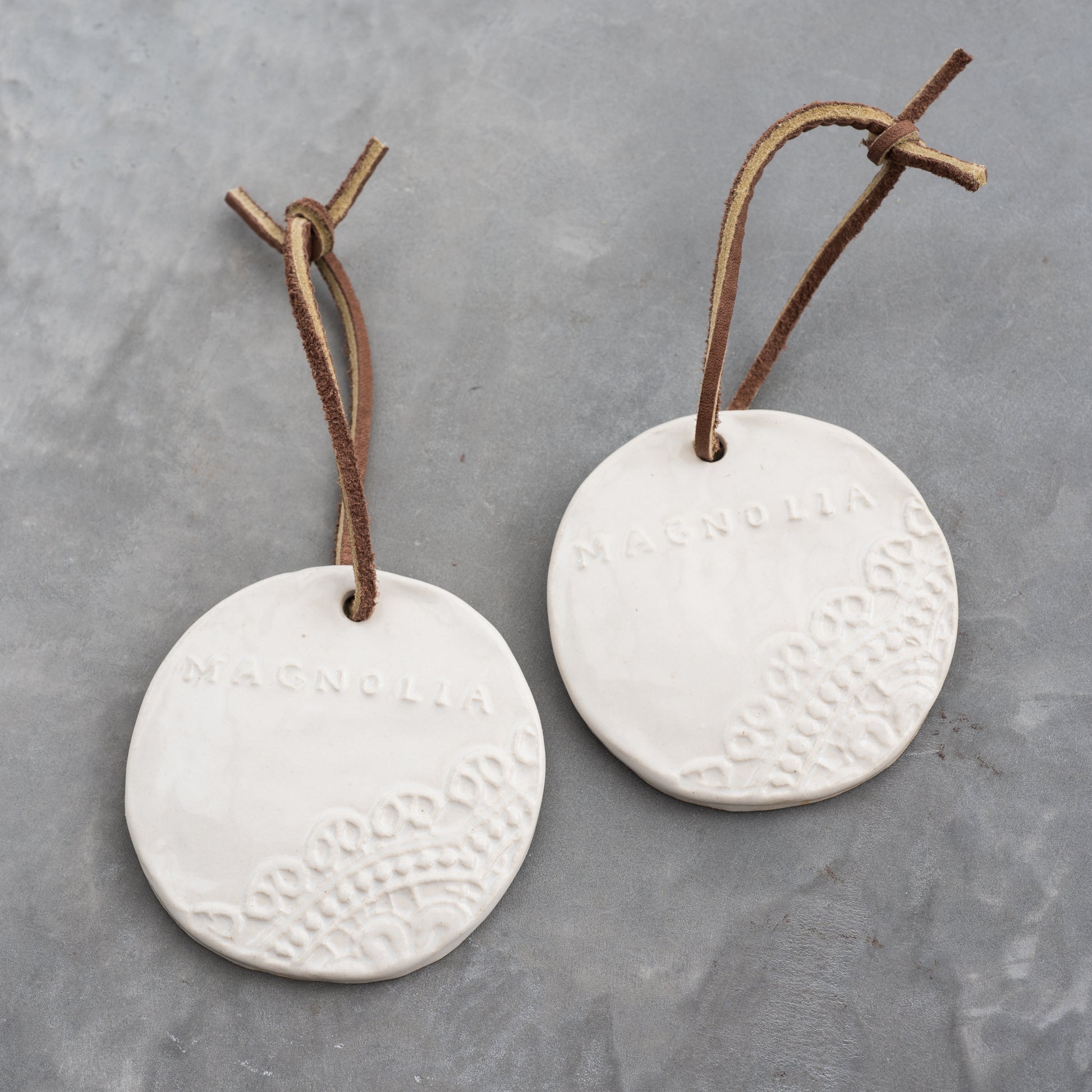 ceramic circle ornament with lace detail and magnolia logo