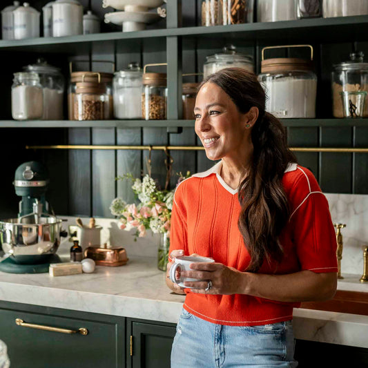 Joanna Gaines holds a cup of coffee in her butler's pantry at the farm—surrounded by cookies and baking essentials.