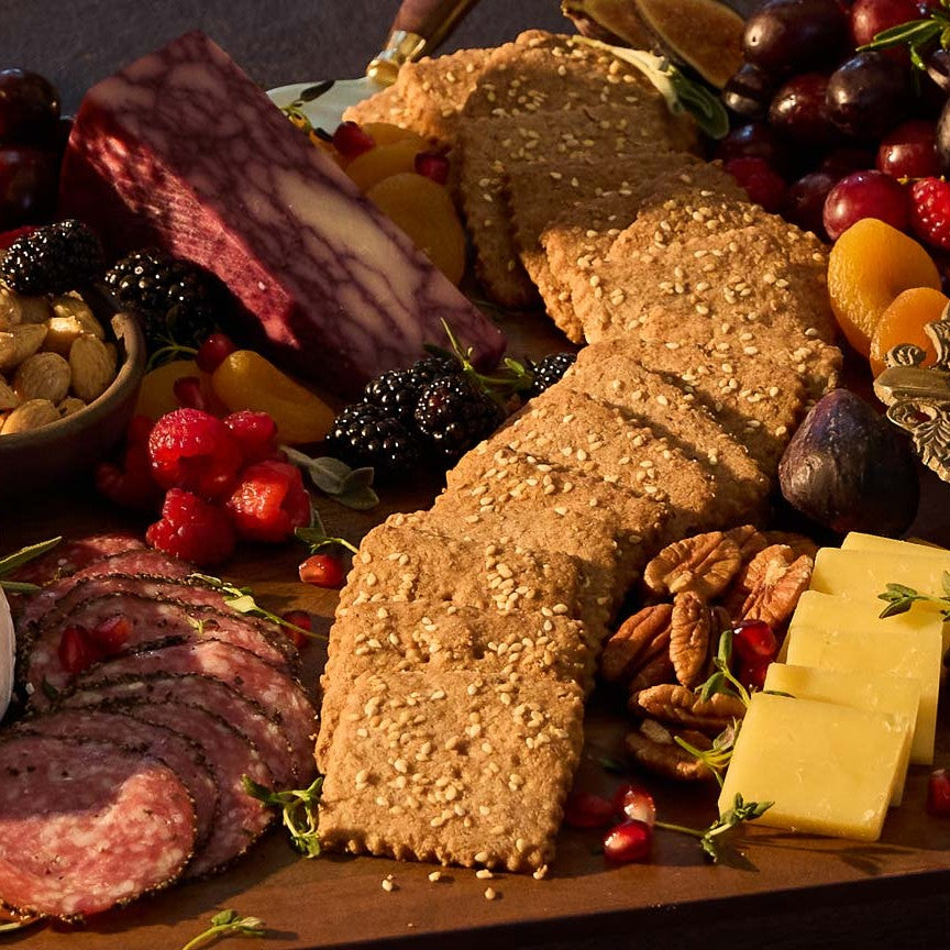A close-up shot of a beautiful charcuterie board filled with cured meats, cheeses, fresh fruits, nuts, and homemade crackers.