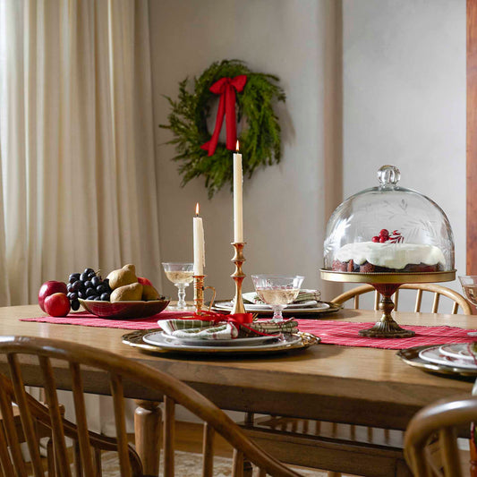 A wooden table set for the holidays, filled with tabletop decor from Magnolia.