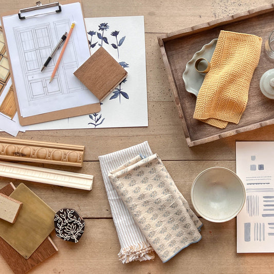 Magnolia-exclusive product sketches, samples, and details sitting on a wooden floor.
