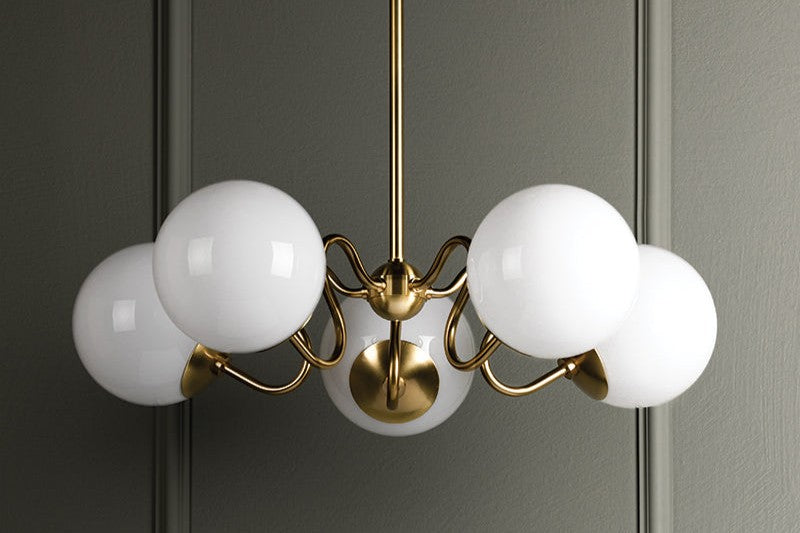 Shop ceiling lighting. Image features a brass curved five arm ceiling fixture with white globes.