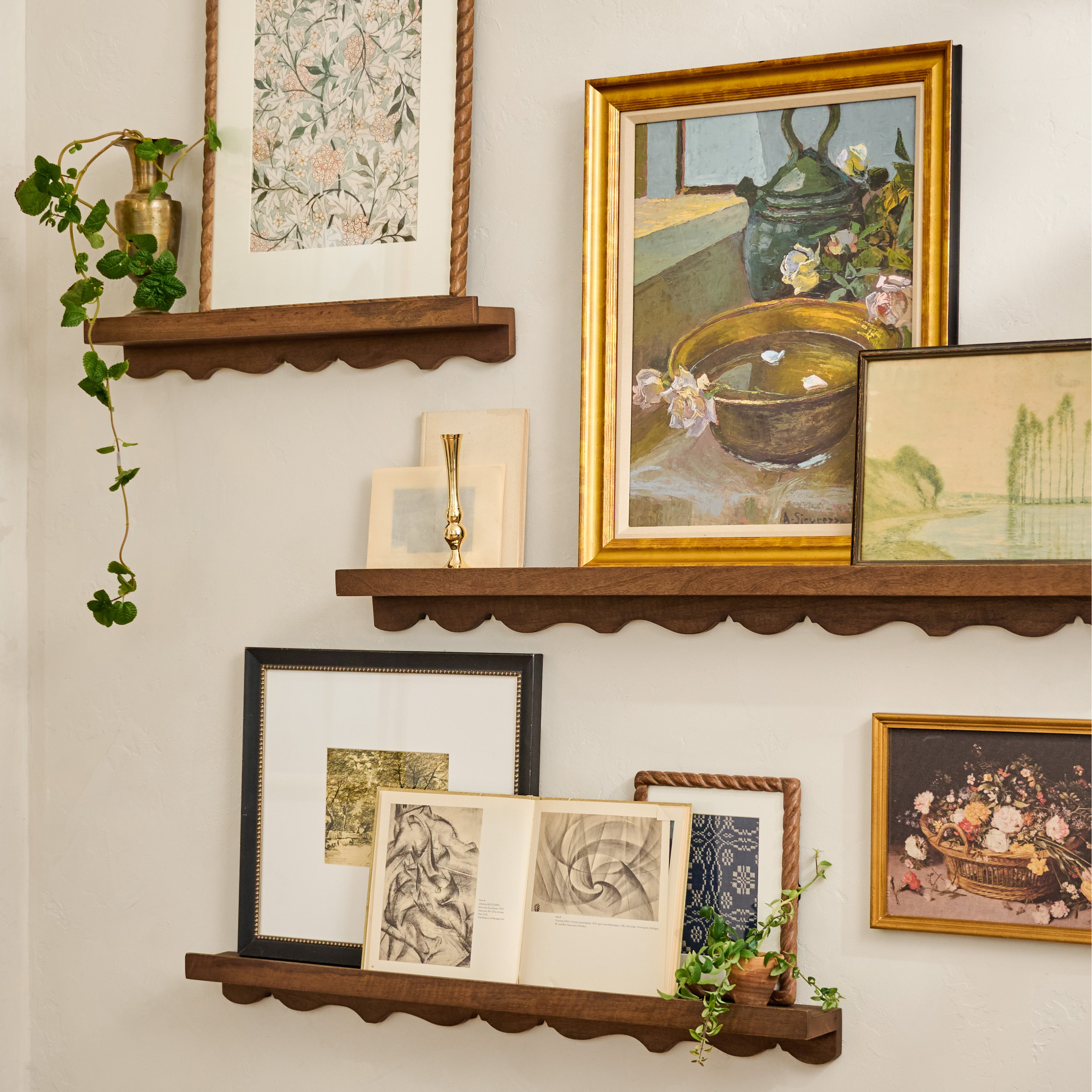 Wall with wooden shelves displaying various framed artworks and decorative items.