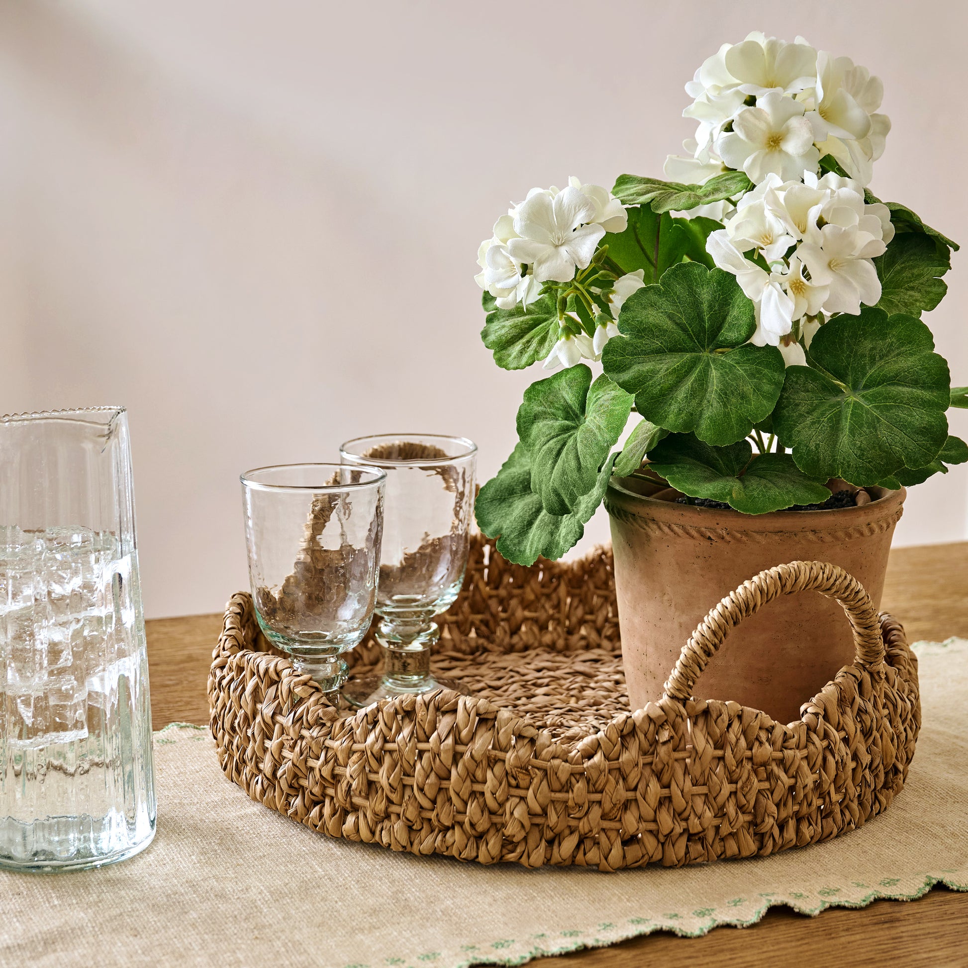Potted White Geranium Flower shown styled with solene woven scalloped tray and glassware