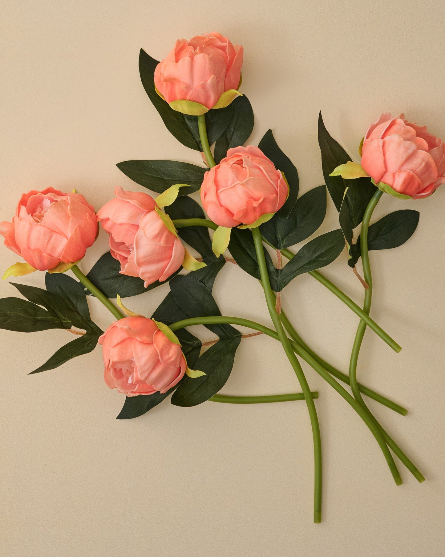 Bouquet of pink artificial peony flowers on a beige background