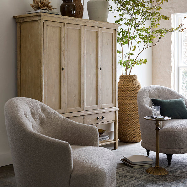 Living room with wooden cabinet, armchairs, and decorative items.