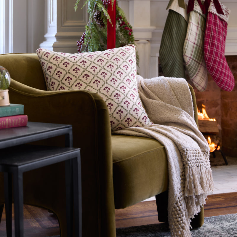 Cozy living room with a green sofa, patterned pillow, and Christmas stockings.