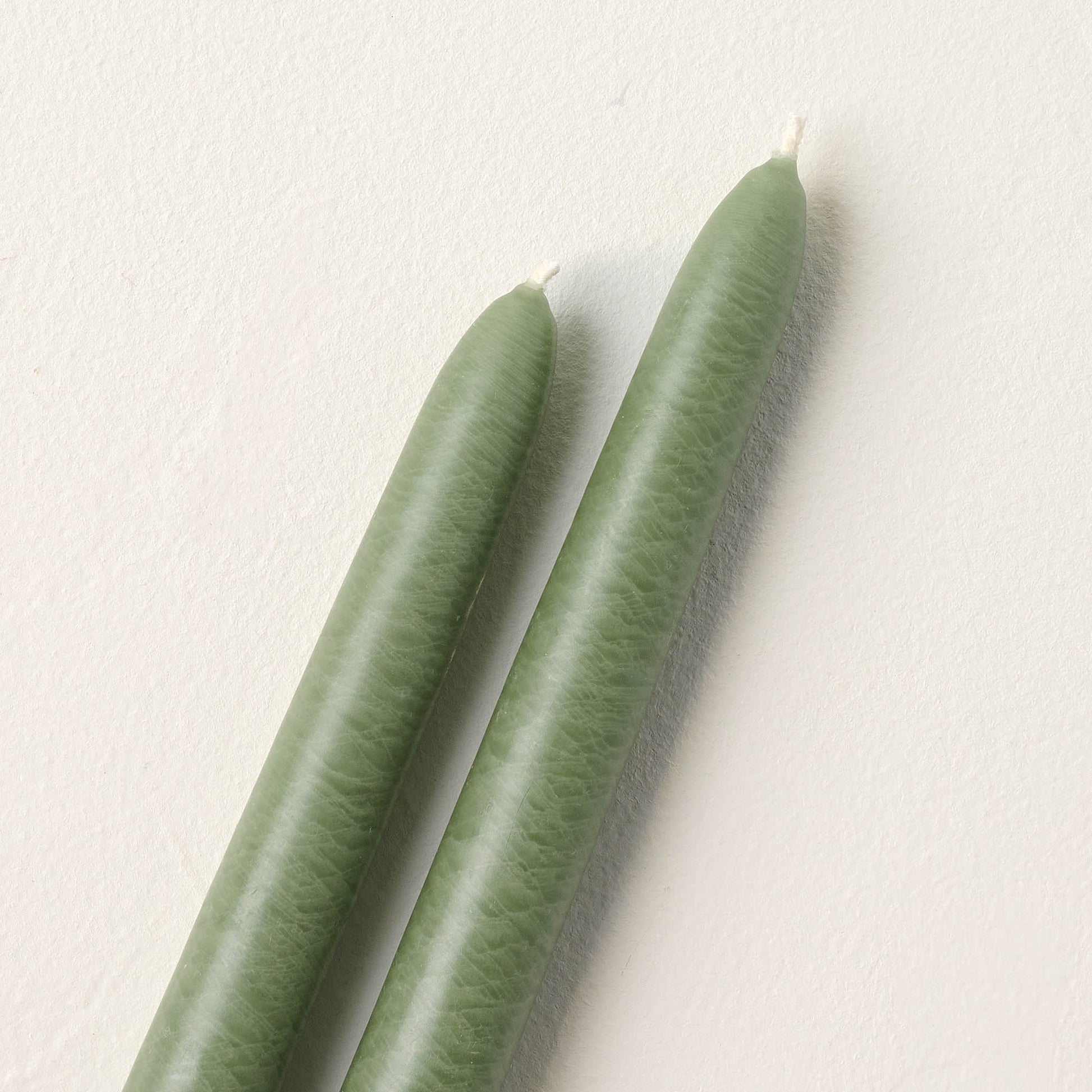 close up view of two colonial green candle taper wicks