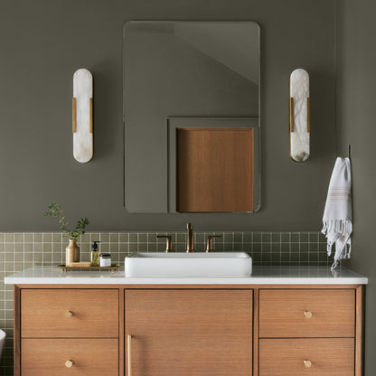 Trailhead paint featured in bathroom walls with marble sconces and light wood cabinetry and white sink