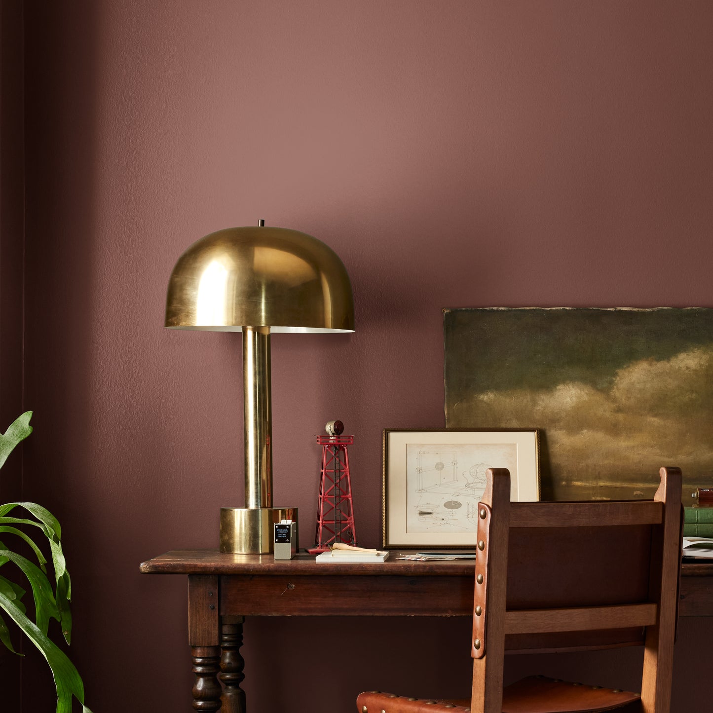 Mountain Currant paint featured in office area wall with brass lamp, wood table and desk chair, pictures
