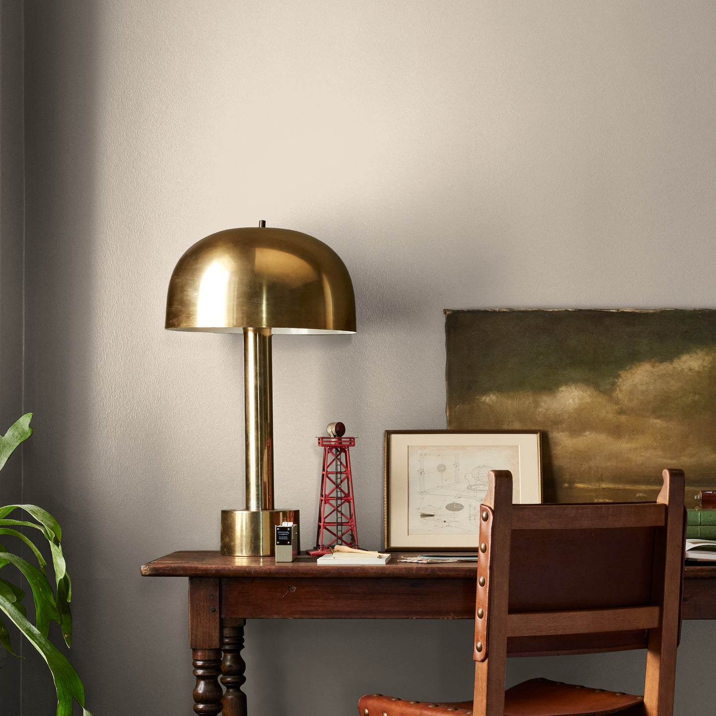 Quaint Cottage paint featured in office area wall with brass lamp, wood table and desk chair, pictures