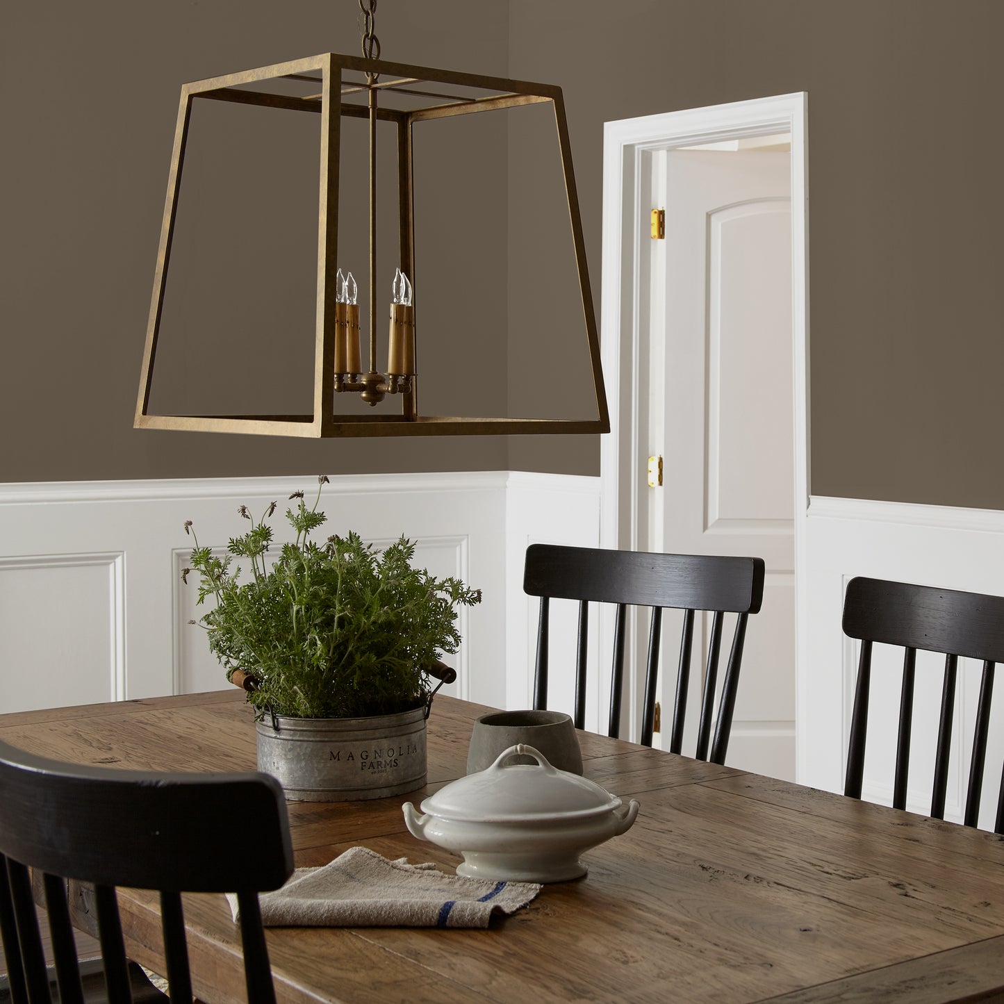 Mosswood paint featured in dining room walls with large brass pendant light and wooden dining table