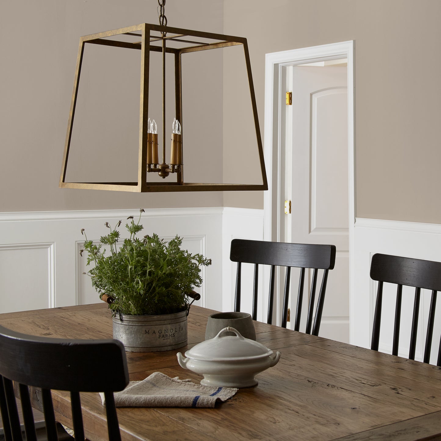 Quaint Cottage paint featured in dining room walls with large brass pendant light and wooden dining table