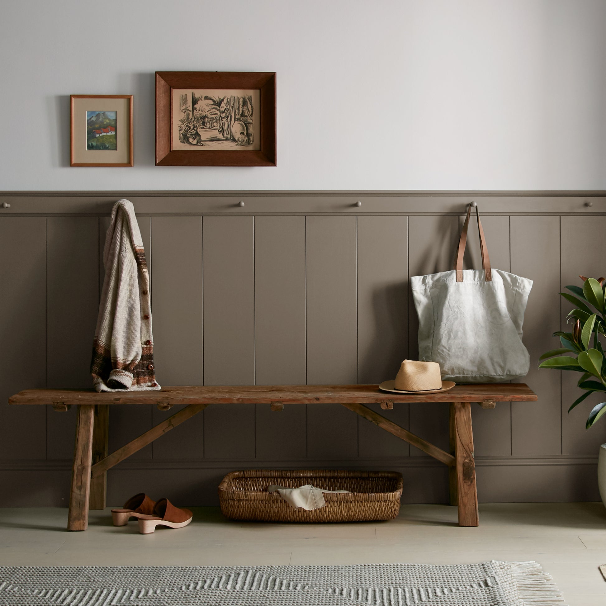 Mosswood paint featured in mudroom on half room paneled walls with hung tote bag and cardigan