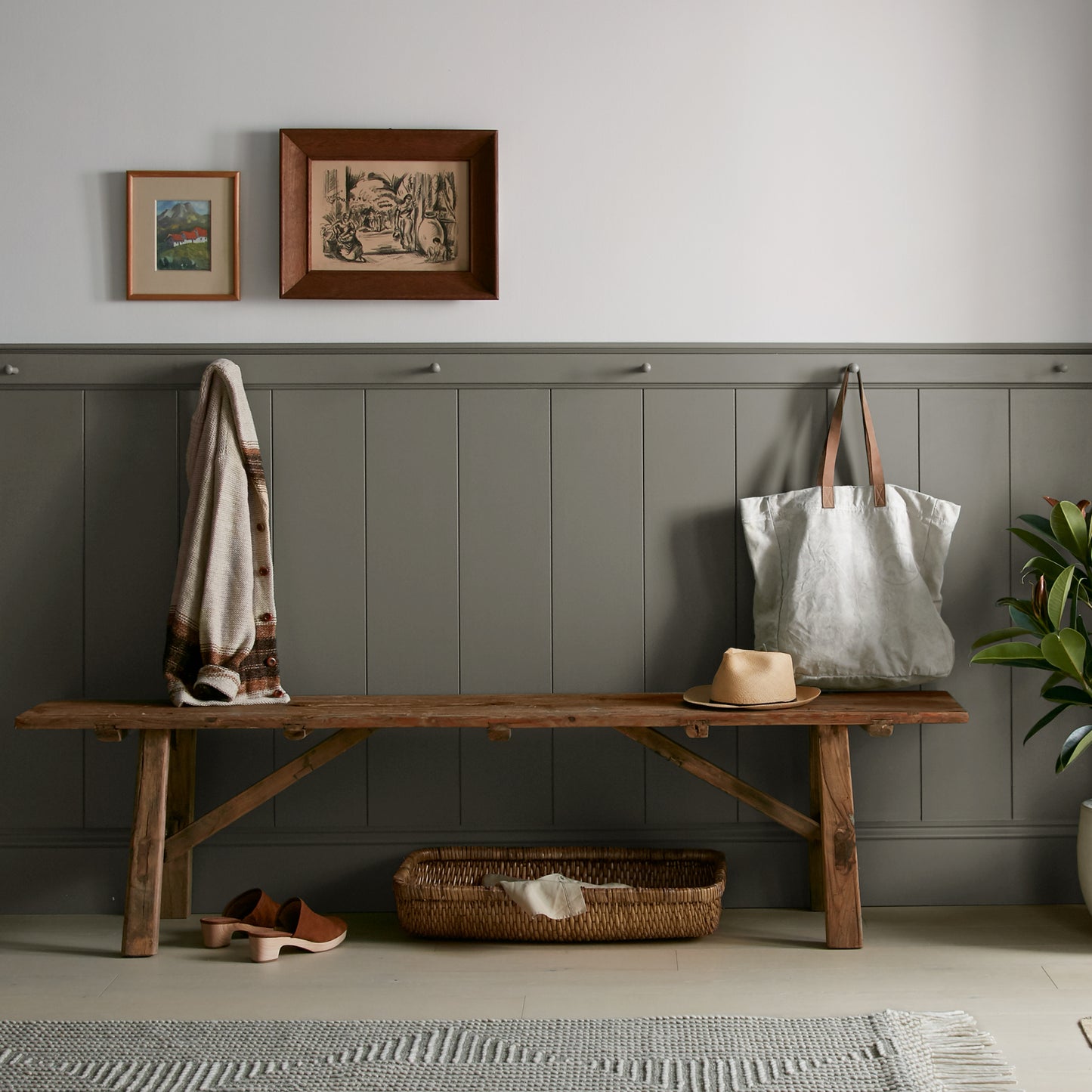 Trailhead paint featured in mudroom on half room paneled walls with hung tote bag and cardigan
