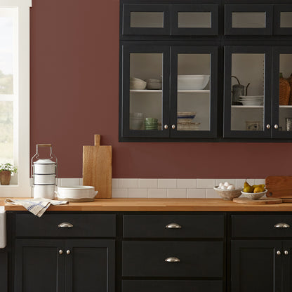 Mountain Currant paint featured in kitchen walls with dark blue cabinets and wood countertops