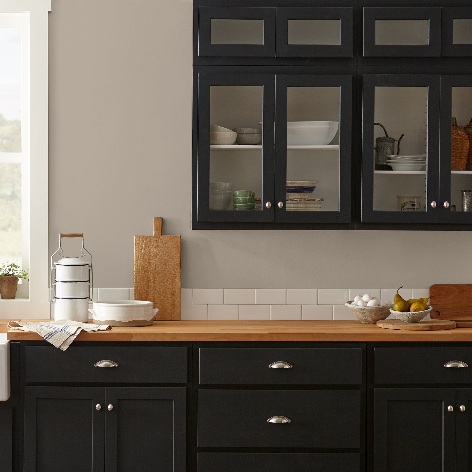 Quaint Cottage paint featured in kitchen walls with dark blue cabinets and wood countertops