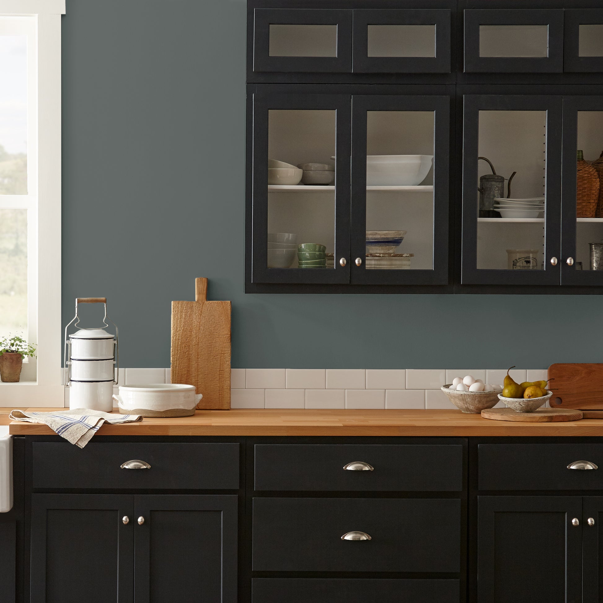 Ridge Rock paint featured in kitchen walls with dark blue cabinets and wood countertops