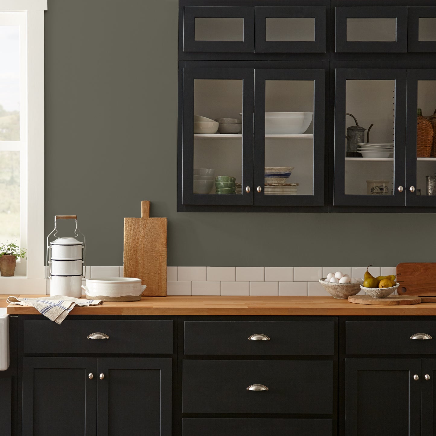 Trailhead paint featured in kitchen walls with dark blue cabinets and wood countertops